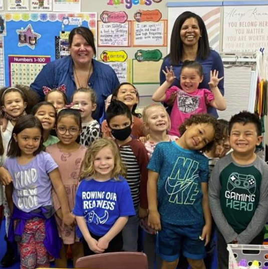  Dr. Logan poses with students in a classroom